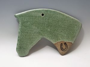 Horsehead ornament in moss with a horseshoe