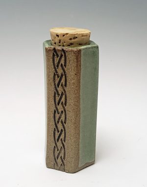 Vial in moss with Celtic design